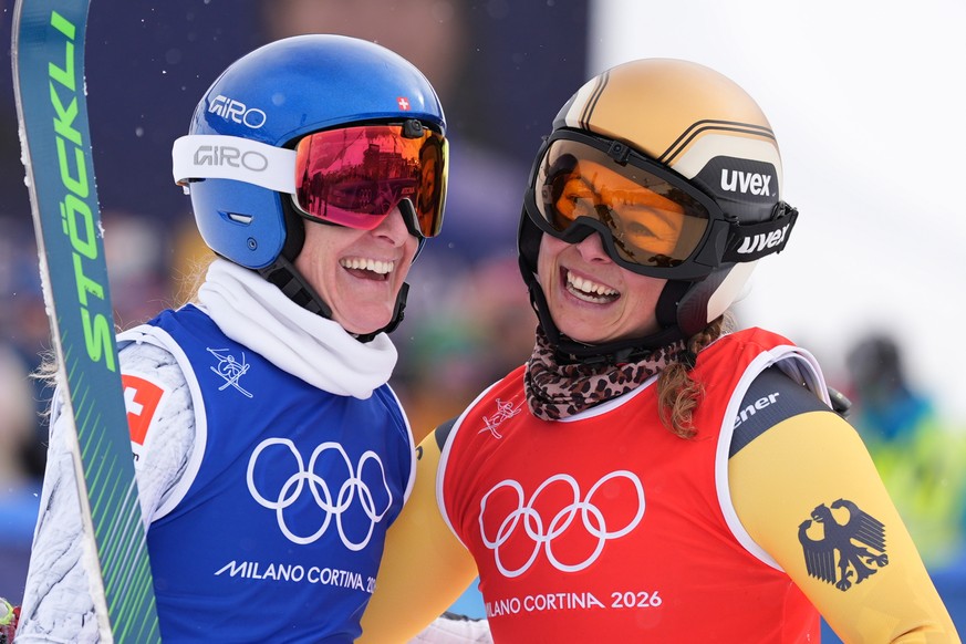 Silver medalist Switzerland's Fanny Smith (3), left, and gold medalist Germany's Daniela Maier (1) embrace after the women's ski cross finals at the 2026 Winter Olympics, in Livigno, It ...