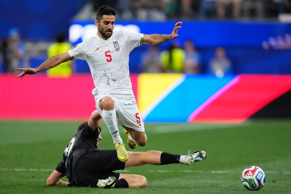 Iran's Milad Mohammadi (5) jumps over New Zealand's Callum McCowatt (20) during the World Cup Group G soccer match between Iran and New Zealand in Inglewood, Calif., near Los Angeles, Monday ...