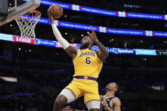 Los Angeles Lakers forward LeBron James, left, shoots as San Antonio Spurs forward Keldon Johnson defends during the first half of an NBA basketball game Wednesday, Jan. 25, 2023, in Los Angeles. (AP  ...
