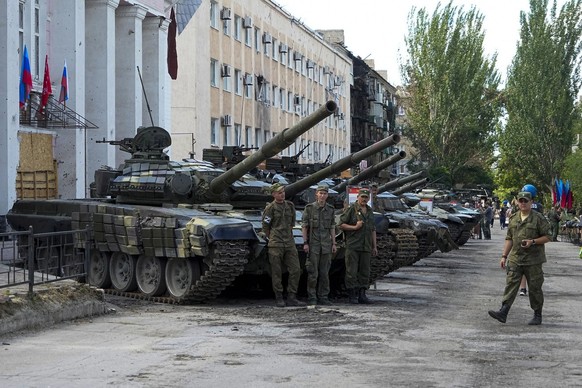 FILE. Luhansk People&#039;s Republic people militia servicemen stand at an exhibition of captured Ukrainian tanks and weapons in Lisichansk, on the territory which is under the Government of the contr ...