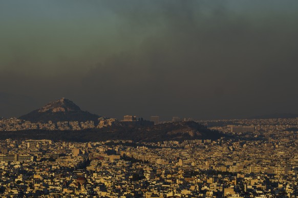 A general view of the of Athens with the Acropolis hill as fire burns the northern part of the city on Monday, Aug. 12, 2024, while hundreds of firefighters tackle a major wildfire raging out of contr ...