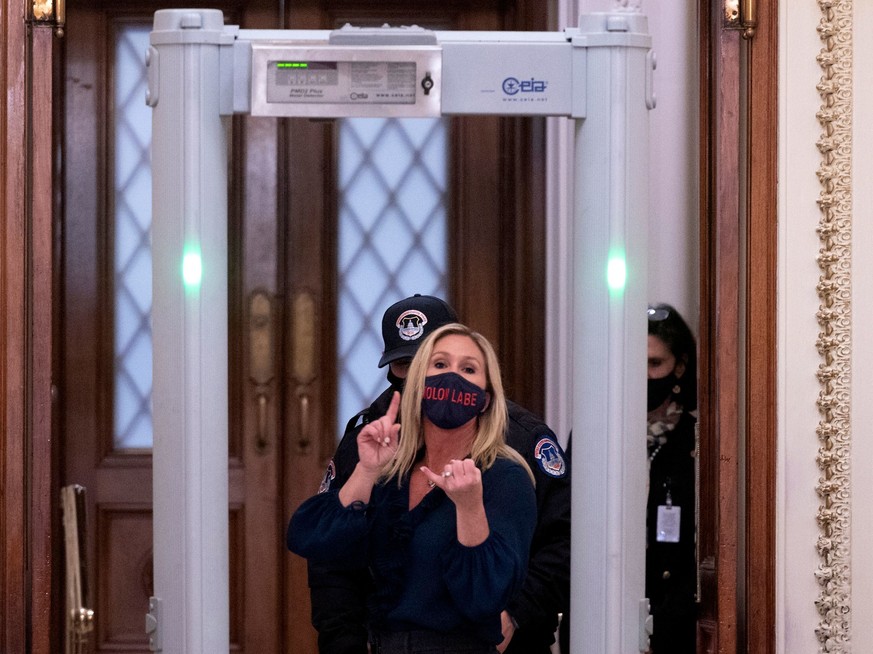 Representative Marjorie Taylor Greene (R-GA) shouts at journalists as she goes through security outside the House Chamber at Capitol Hill in Washington, DC on January 12, 2021. - On the eve of his lik ...