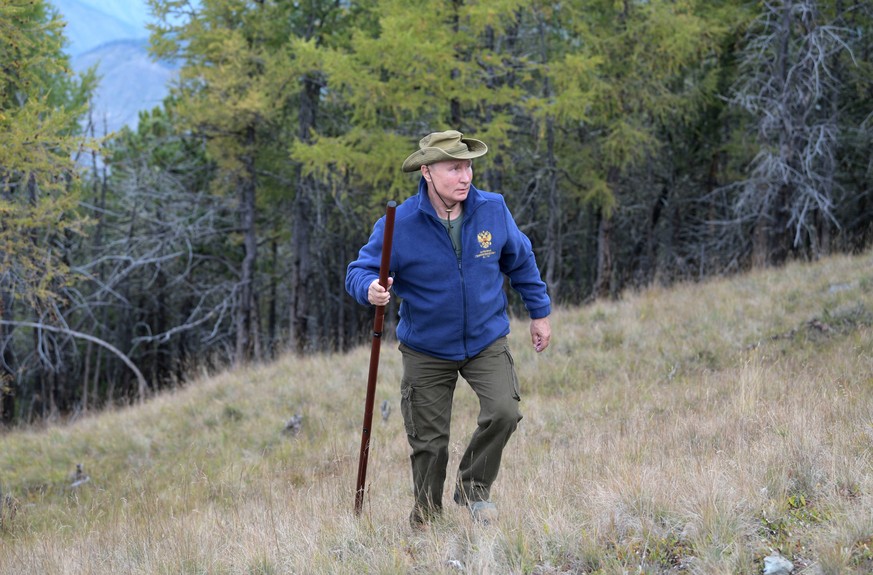 In this undated photo released by Russian Presidential Press Service, Russian President Vladimir Putin walks up a hill in Siberia during a break from state affairs ahead of his birthday. Russian presi ...