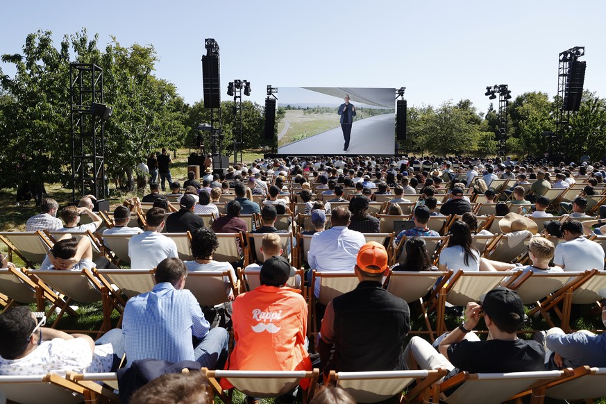 epa09999356 Apple CEO Tim Cook appears on a huge screen outside during the 2022 Apple Worldwide Developers Conference (WWDC) on the campus of Apple Park in Cupertino, California, USA, 06 June 2022. Th ...