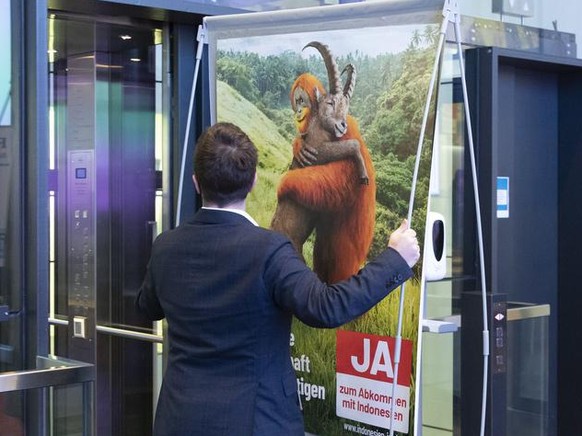 Ein Mitglied des Komitees stellt ein Abstimmungsplakat neben Fabian Molina, Nationalrat SP-ZH, Mitte, und Laurent Wehrli, Nationalrat FDP-VD, rechts, in den Lift, am Ende einer Medienkonferenz des Kom ...