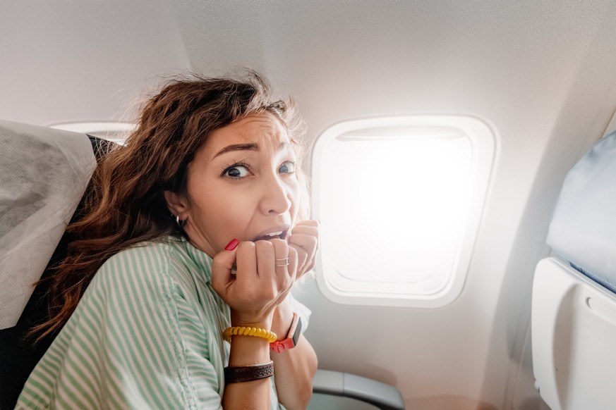 Une femme en panique dans un avion.
