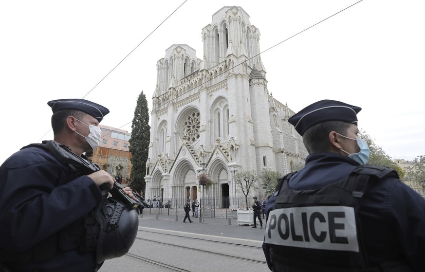 Police officers stand guard near Notre Dame church in Nice, southern France, Thursday, Oct. 29, 2020. An attacker armed with a knife killed at least three people at a church in the Mediterranean city  ...