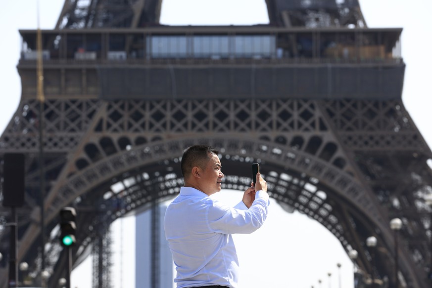 A tourist makes a selfie near the Eiffel Tower Wednesday, Aug. 31, 2022 in Paris. Tourism came back with a vengeance to France this summer, sending revenues over pre-pandemic levels according to gover ...