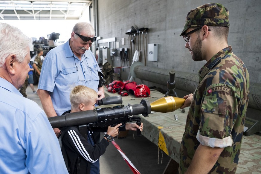 Un enfant prend dans ses mains une arme atichar panzerfaust lors des celebrations des 50 ans de la place d&#039;armes de l&#039;armee suisse ce samedi 16 juin 2018 a Bure dans le Jua. (KEYSTONE/Jean-C ...