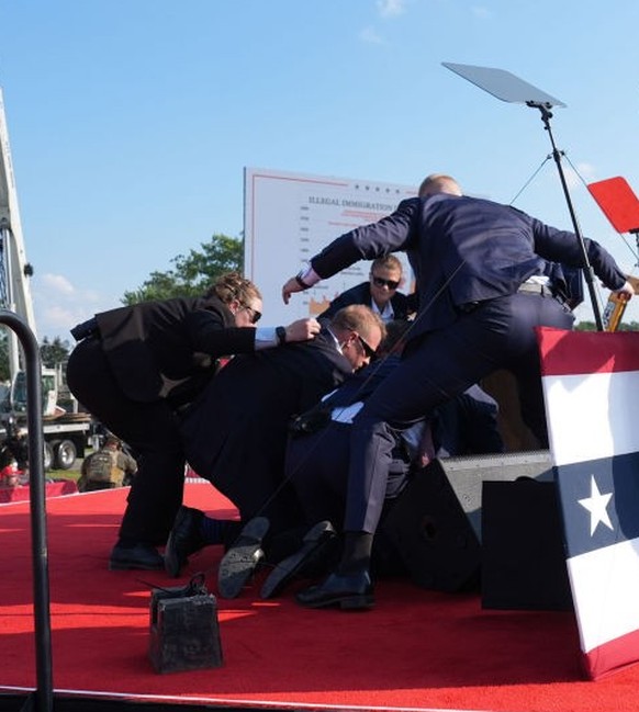 BUTLER, PENNSYLVANIA - July 13: Secret service agents cover former president Donald Trump during a campaign rally for former President Donald Trump at Butler Farm Show Inc. on Saturday, July 13, 2024  ...