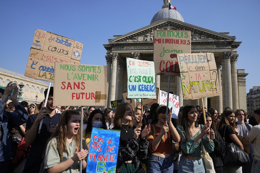 Demonstrators hold posters in front of Le Pantheon monument during a climate protest Friday, March 25, 2022 in Paris. Climate activists staged a series of worldwide protests Friday to demand that lead ...