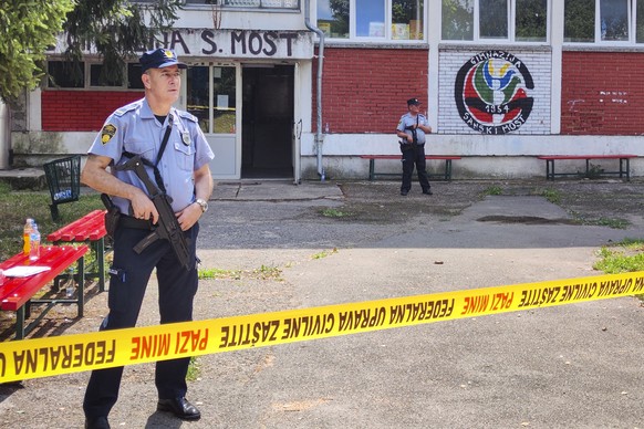 Police officers stand in front of a secondary school building in Sanski Most, northwest of Bosnia&#039;s capital, Sarajevo, Wednesday, Aug. 21, 2024, after a school employee shot and killed three peop ...