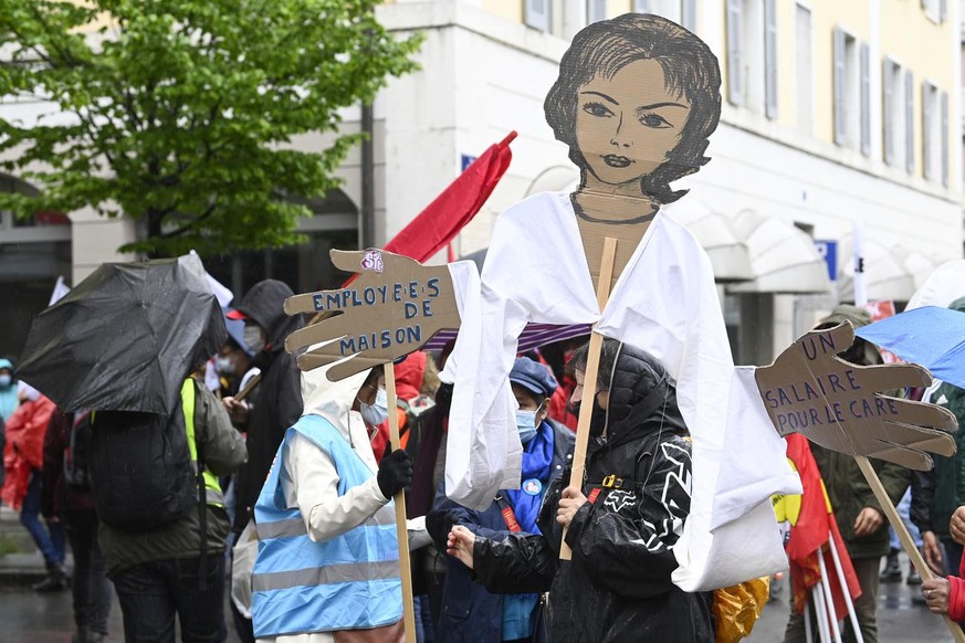 Des manifestants avec des pancartes et des drapeaux defilent dans les rues de Geneve, lors du defile du 1er mai - Fete du Travail, ce samedi 1 mai 2021 a Geneve. Le traditionnel cortege du 1er mai, pl ...