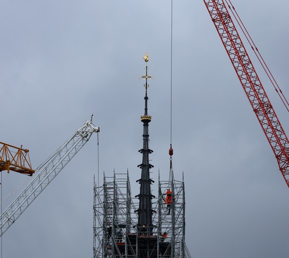 Scaffolding is being removed around the spire of Notre Dame de Paris cathedral, showing the rooster and the cross, Monday, Feb. 12, 2024 in Paris. Notre Dame is expected to reopen in Dec. 2024 followi ...