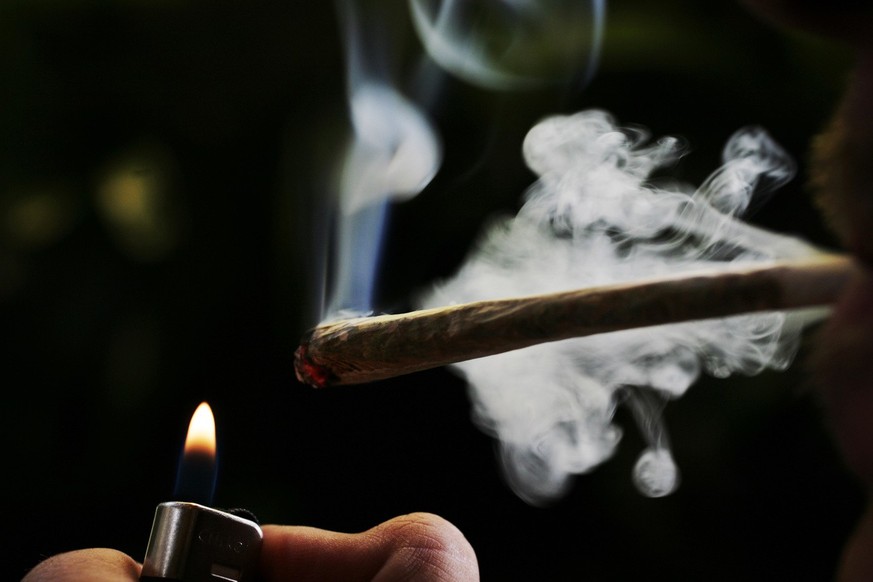 In this June 24, 2008 file image a regular user of soft drugs lights a marijuana joint in a coffee shop in Amsterdam, Netherlands. The Dutch parliament approved controlled growing of marijuana or weed ...