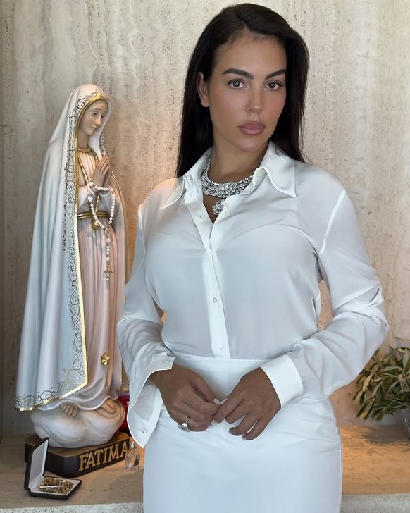 Georgina arborait une chemise et une jupe blanches transparentes, des chaussures en satin assorties.