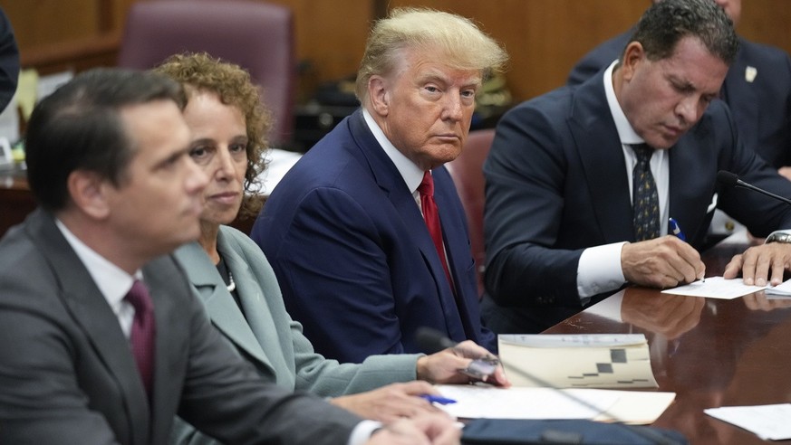 Former President Donald Trump sits at the defense table with his defense team in a Manhattan court, Tuesday, April 4, 2023, in New York. Trump is set to appear in a New York City courtroom on charges  ...