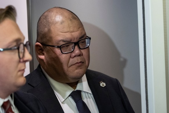 White House communications director Steven Cheung listens as President Donald Trump speaks with reporters while in flight on Air Force One from Joint Base Andrews to his Mar-a-Lago estate in Palm Beac ...