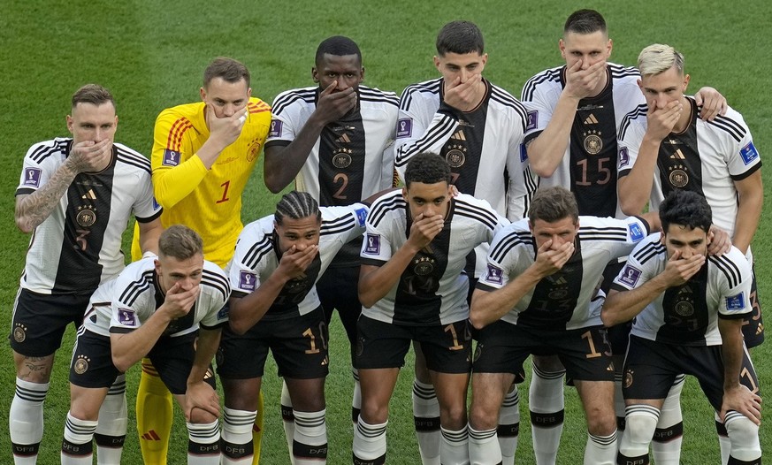 Germany&#039;s soccer team players cover their mouths as they pose for a group photo before the World Cup group E soccer match between Germany and Japan, at the Khalifa International Stadium in Doha,  ...