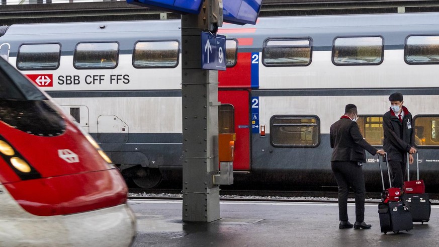 Two employees of the railway compagny CFF/SBB wait for a train at the train CFF/SBB station during the spread of the pandemic Coronavirus (COVID-19) disease in Lausanne, Switzerland, Monday, May 11, 2 ...