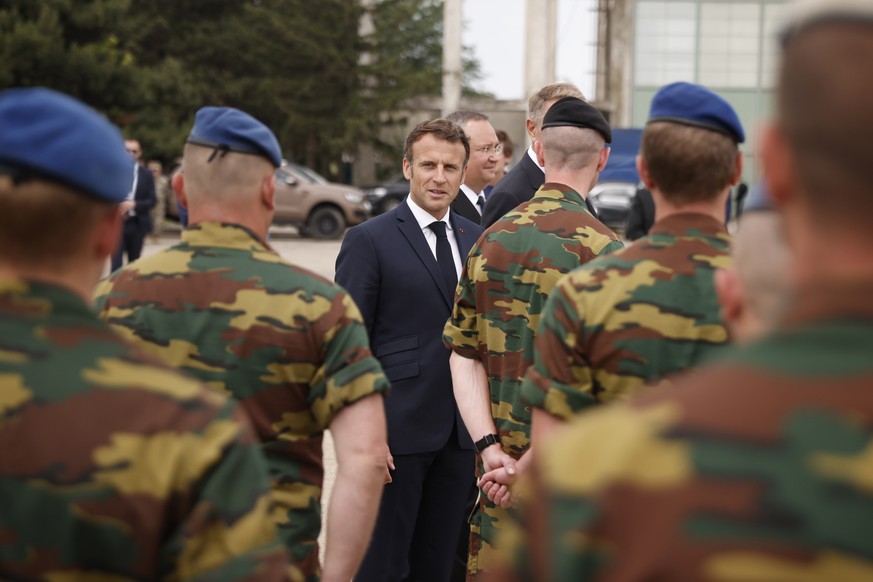 epa10013984 French President Emmanuel Macron (C) meets with Belgian NATO forces during his visit at the Mihail Kogalniceanu Air Base, near the city of Constanta, Romania, 15 June 2022. Macron is visit ...