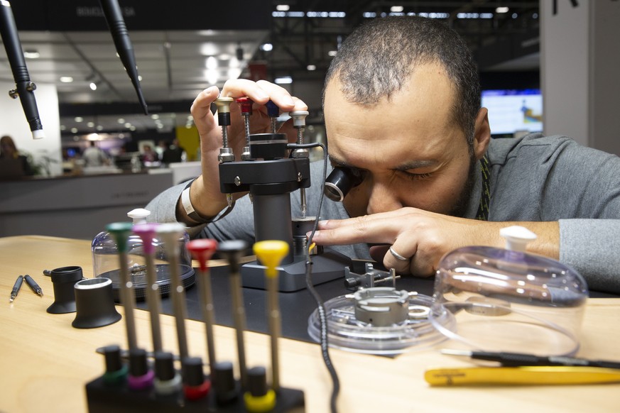 A worker assembles a watch dial at the booth Bergeon during the EPHJ exhibition, at Palexpo in Geneva, Switzerland, Tuesday, September 14, 2021. EPHJ is the most important professional show held annua ...