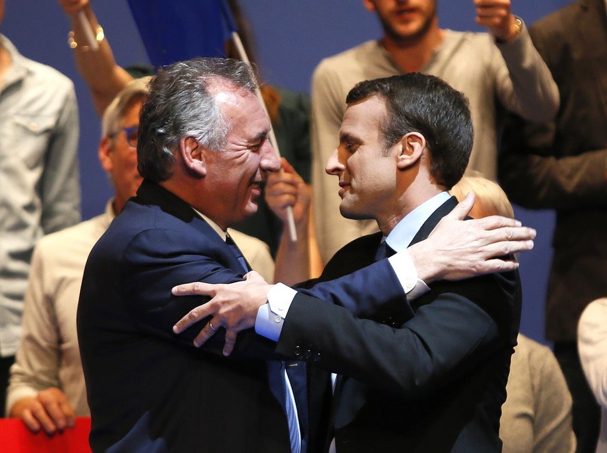 French centrist presidential election candidate Emmanuel Macron, right, and French centrist politician Francois Bayrou embrace during a meeting in Pau, southwestern France, Wednesday, April 12, 2017.  ...