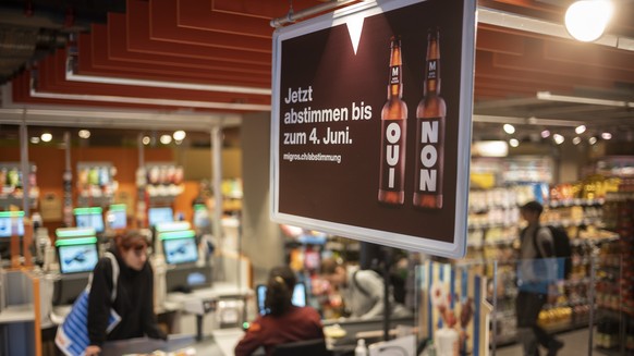 Plakate weisen auf die Abstimmung zum moeglichen Verkauf von alkoholischen Getraenken in der Migros hin, am Dienstag, 24. Mai 2022 in der Migros Filiale Lorraine in Bern. Anfang Juni 2022 koennen die  ...
