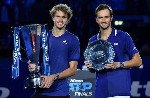epa09596640 Alexander Zverev (L) of Germany poses with the trophy after winning the final match against Daniil Medvedev (R) of Russia at the Nitto ATP Finals tennis tournament in Turin, Italy, 21 Nove ...