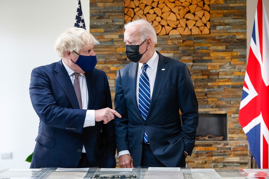epa09260814 Boris Johnson, Britain&#039;s Prime Minster, gestures to US President Joe Biden, right, as they look at the Atlantic charter during their bilateral meeting in Carbis Bay, Britain, 10 June  ...