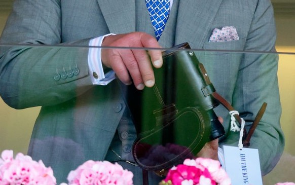 ASCOT, UNITED KINGDOM - JUNE 21: (EMBARGOED FOR PUBLICATION IN UK NEWSPAPERS UNTIL 24 HOURS AFTER CREATE DATE AND TIME) King Charles III removes his binoculars from their case (with an &#039;HM The Ki ...