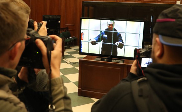 epa09952071 Russian opposition leader Alexei Navalny is shown on a monitor screen via video link from the IK-2 corrective penal colony in Pokrov, at the Moscow City court before a hearing of an appeal ...