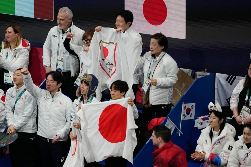 Team Japan react while watching Utana Yoshida and Masaya Morita compete during the figure skating ice dance team event at the 2026 Winter Olympics, in Milan, Italy, Friday, Feb. 6, 2026. (AP Photo/Ash ...