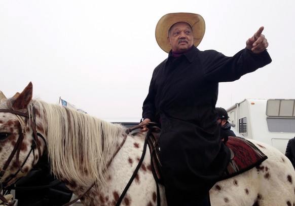 FILE - Civil rights activist Jesse Jackson sits atop a horse while visiting the protest camp against the Dakota Access oil pipeline outside Cannon Ball, N.D, Oct. 26, 2016. (AP Photo/James MacPherson, ...