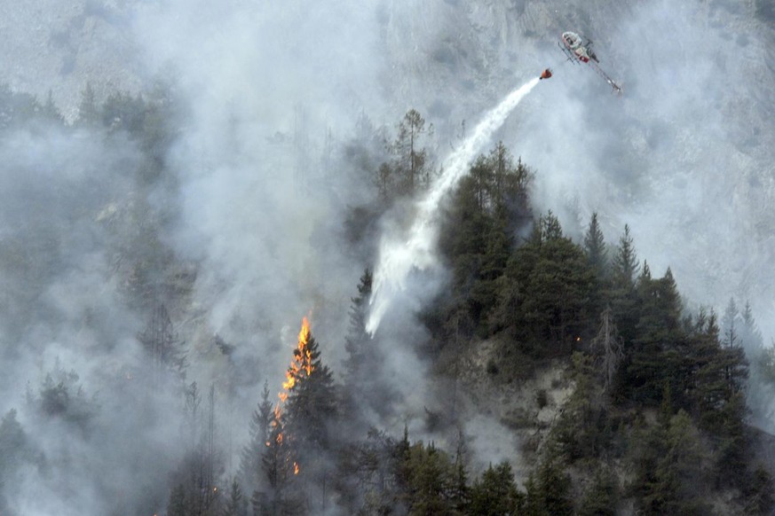 Un helicoptere qui deverse de l&#039;eau sur une foret en feu au dessus de Chamoson est pris en photo ce mercredi 22 aout 2012 a Chamoson...Un feu de foret s&#039;est developpe mercredi vers 12h45 au  ...