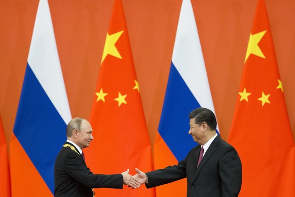 FILE - Chinese President Xi Jinping, right, and Russian President Vladimir Putin shake hands during an awarding ceremony at the Great Hall of the People in Beijing, China, on June 8, 2018. Xi is keepi ...