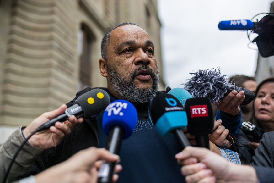 French controversial humorist Dieudonne MBala MBala speaks to the journalists after leaving the courthouse to testify at the Tariq Ramadan trial for a second day of hearing with Geneva&#039;s prosecut ...