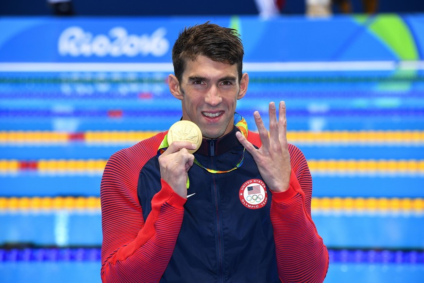 epa05476075 Michael Phelps of USA celebrates his fourth Rio 2016 gold medal during the medal ceremony for the men&amp;#039;s 200m Individual Medley Final race of the Rio 2016 Olympic Games Swimming ev ...