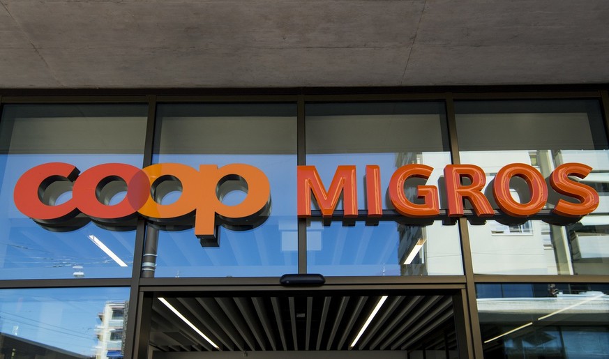 Le logo de la Coop et le logo de la Migros sont photographies cote a cote sur un batiment commercial commun ce mardi 23 aout 2016 sur la place de la Sallaz a Lausanne. (KEYSTONE/Jean-Christophe Bott)