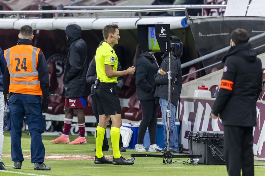 The referee Sven Wolfensberger checks the VAR screen, during the Super League soccer match of Swiss Championship between Servette FC, SFC, and FC Lugano, LUG, at the Stade De Geneve in Geneva, Switzer ...