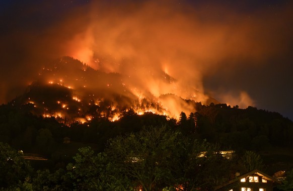 De la fumee et des flammes s'echappent de la foret en feu au dessus des communes de Bitsch et Ried-Moerel ce lundi 17 juillet 2023 depuis Naters. Un incendie de foret s'est declare lundi au- ...