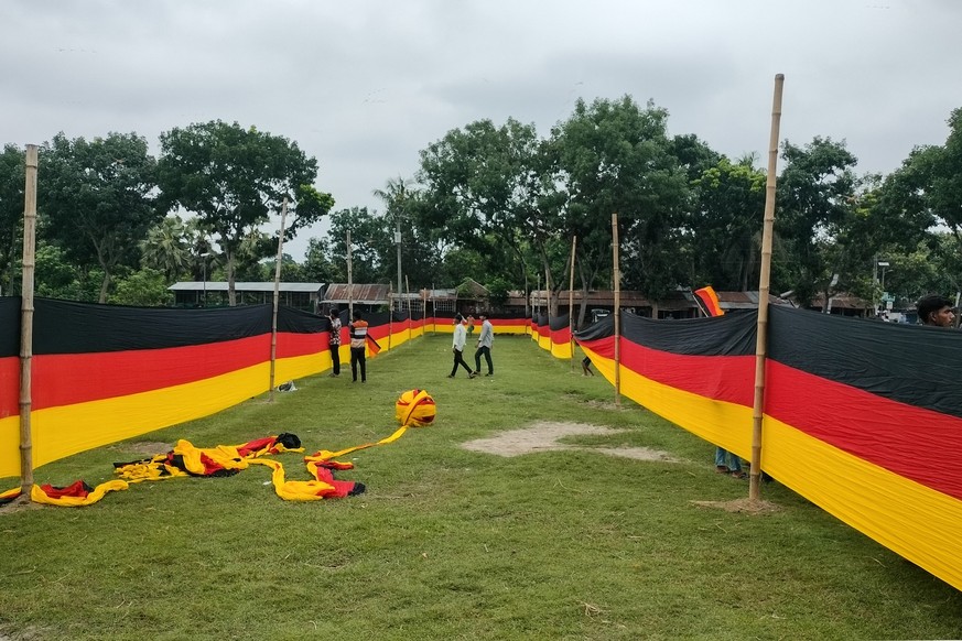 People look at a 7.5 kilometres (4.7 miles) long national flag of Germany commisioned by their football team fan Bangladeshi farmer Amjad Hossain, upon its display across a field in Magura district on ...