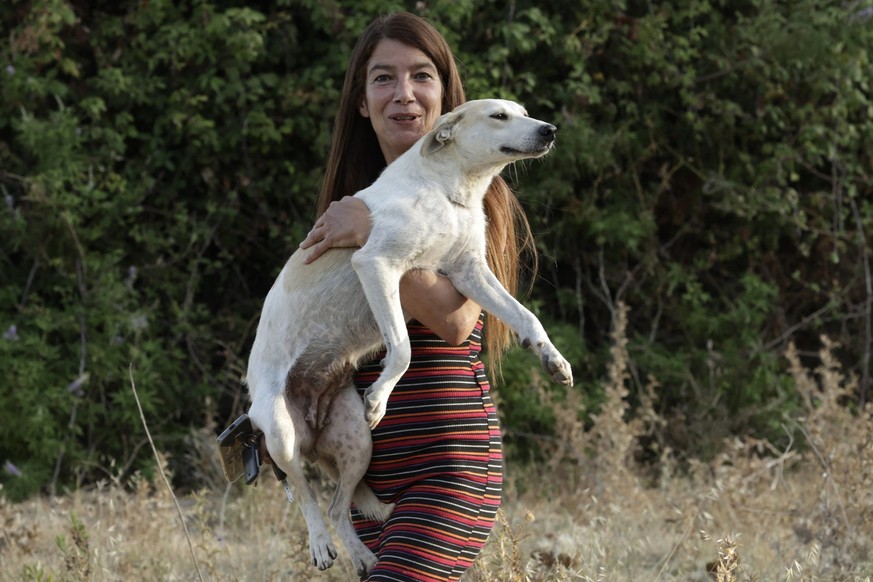 Salima Kadaoui, founder of SFT (Sanctuaire de la Faune de Tanger), carries a stray dog near her home in Tangiers on July 24, 2025. Animal welfare groups have accused Morocco of culling stray dogs ahea ...