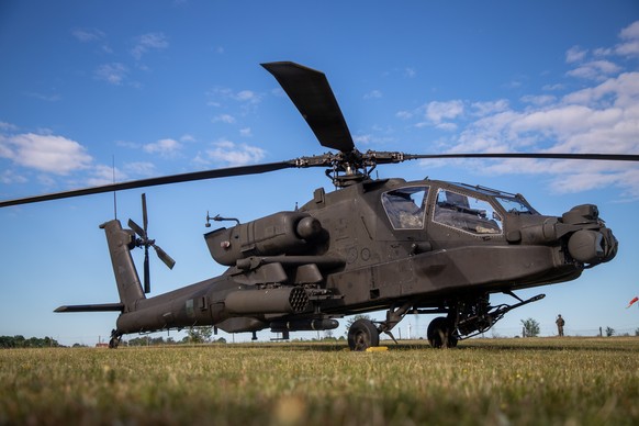 epa13001472 A Boeing AH-64 Apache helicopter is parked on a field during the 'Polish Apache Initiative 4 / European HIMARS Initiative 8' joint military exercise at a training ground in Kijew ...