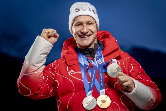 Silver medalist Switzerland's Marco Odermatt poses with his medals after the men's alpine skiing giant slalom race at the 2026 Olympic Winter Games at the Stelvio Ski centre in Bormio, Italy ...