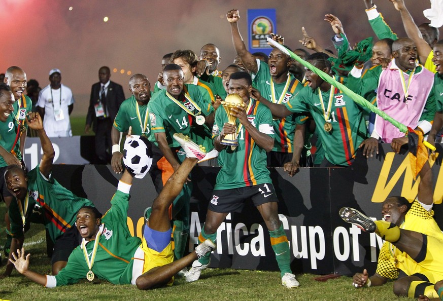 Zambia captain Christopher Katongo, center, holds the trophy of the African Cup of Nations after their final soccer match against Ivory Coast at Stade de L'Amitie in Libreville, Gabon, Sunday, Fe ...