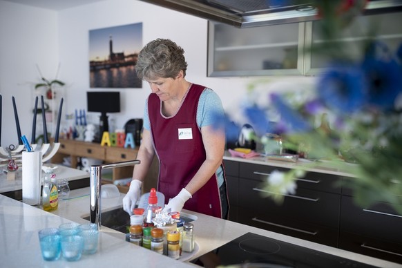 An employee of Spitex (division Thun) does the dishes of a woman with a physical disability (not pictured), at her home in Thun, in the Canton of Bern, Switzerland, on September 16, 2019. (Spitex Schw ...