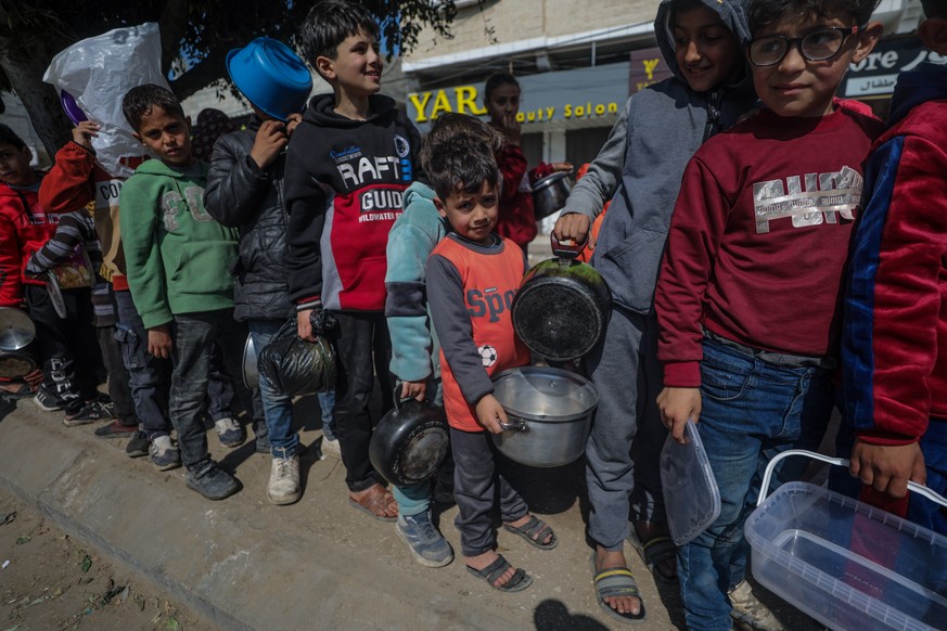 Ces enfants palestiniens sont dans l'attente de pouvoir manger, à Deir Al Balah, au sud de la bande de Gaza.