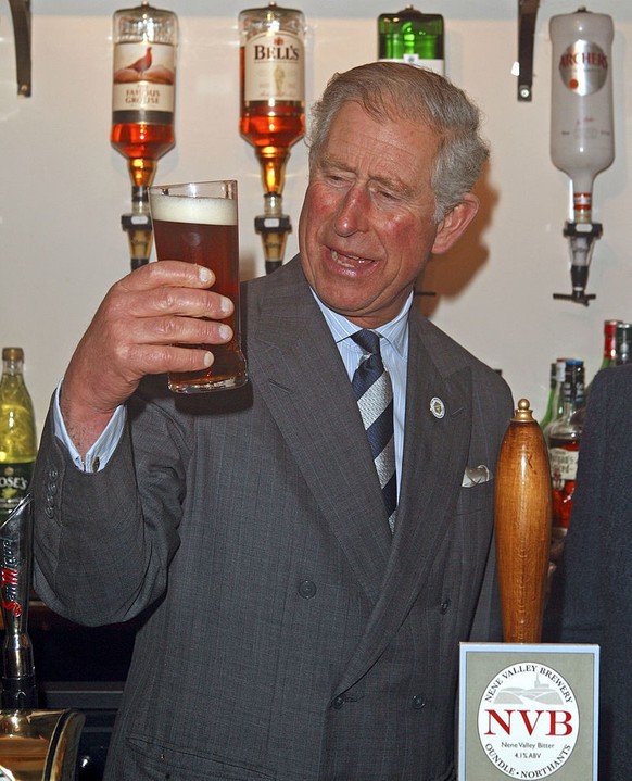 GRANTHAM, UNITED KINGDOM - NOVEMBER 29: (EMBARGOED FOR PUBLICATION IN UK NEWSPAPERS UNTIL 48 HOURS AFTER CREATE DATE AND TIME) Prince Charles, Prince of Wales holds a pint of &#039;Newton&#039;s Drop& ...