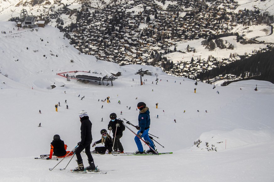 Des skieurs portant des masques chirurgicaux contre le Coronavirus (Covid-19) descendent une piste de ski le dimanche 26 decembre 2021 a Verbier dans le Val de Bagnes. (KEYSTONE/Jean-Christophe Bott)